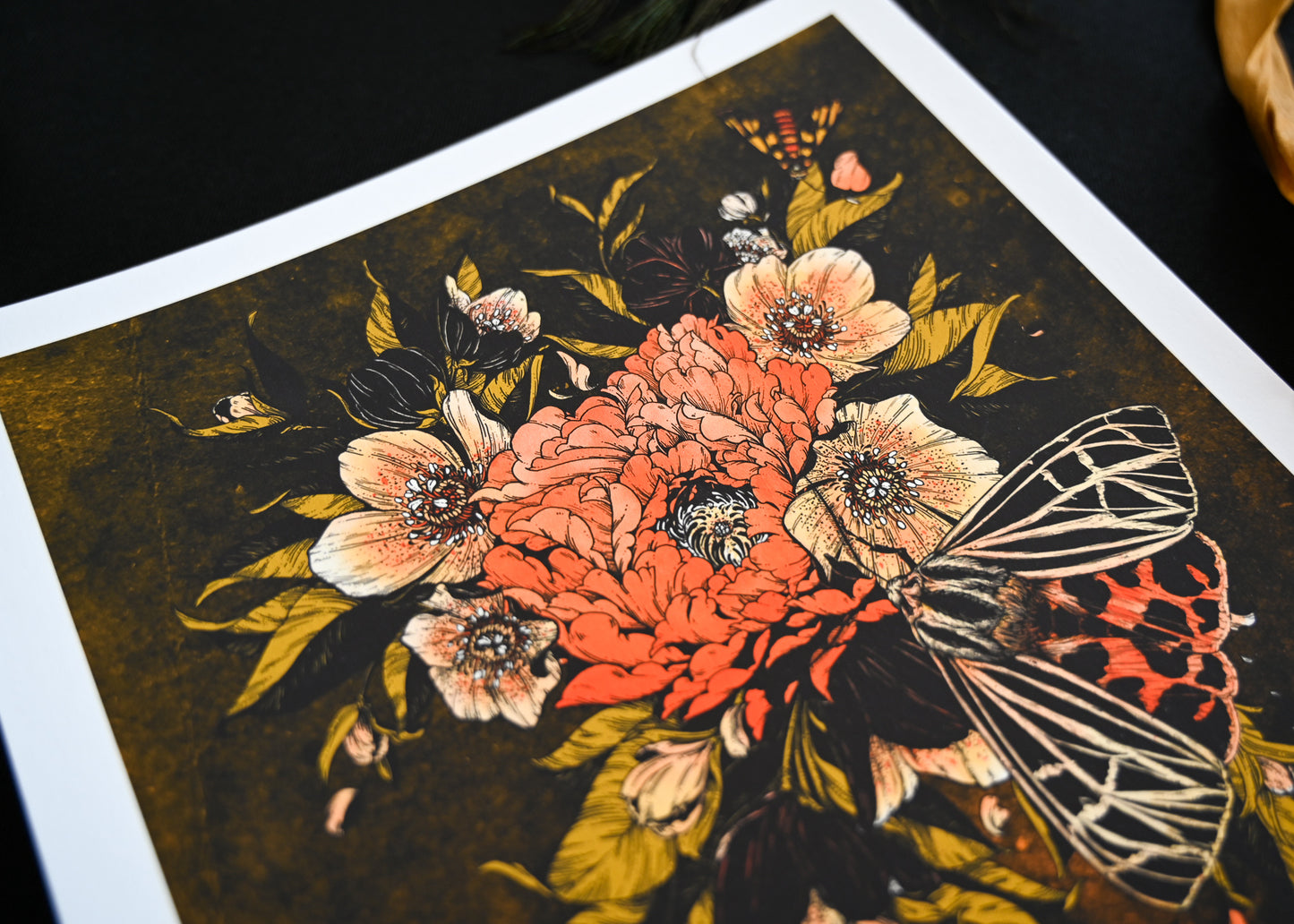 An up close of the top half of the print showing the delicate line work on the flowers. The largest moth is slightly blured.