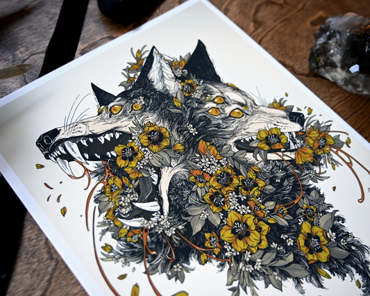 An up close photo of the print. You can see the wolf heads clearly. The rest of the print is cut off. You can see the ribbon and crystal on the table.  